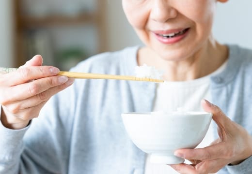 高齢の女性がご飯を食べている手元の様子